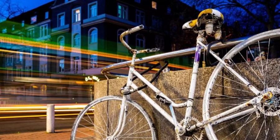 Fahrzeuge fahren an einem sogenannten «Ghost Bike» vorbei, welches an einer Kreuzung in Hannover an einen tödlich verunglückten Fahrradfahrer erinnert. Foto: Moritz Frankenberg/dpa