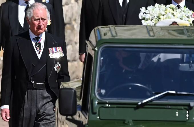 Prinz Charles geht neben dem umgebauten Landrover, auf dem der Sarg seines Vaters steht. Prinz Philip