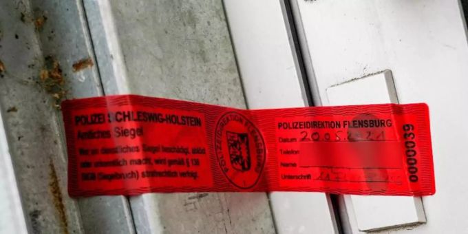 Ein Polizeisiegel klebt an einem Hauseingang in Kiel. In dem Haus wurde nach den Todesschüssen von Dänischenhagen eine dritte Leiche gefunden. Foto: Axel Heimken/dpa Ein Polizeisiegel klebt an einem Hauseingang in Kiel. In dem Haus wurde nach den Todesschüssen von Dänischenhagen eine dritte Leiche gefunden. Foto: Axel Heimken/dpa