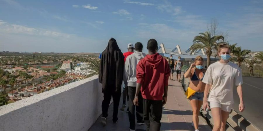 Migranten zwischen Touristen auf Gran Canaria