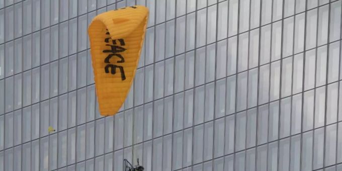 Mit einem Gleitschirm landet ein Greenpeace-Aktivist auf dem Dach der Europäischen Zentralbank (EZB). Foto: Boris Roessler/dpa Greenpeace Gleitschirm