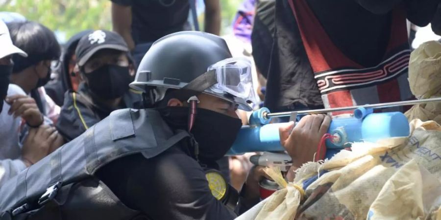 Ein Anti-Putsch-Demonstrant bereitet sich mit einem provisorischen Luftgewehr auf die Konfrontation mit der Polizei vor. Foto: AP/dpa