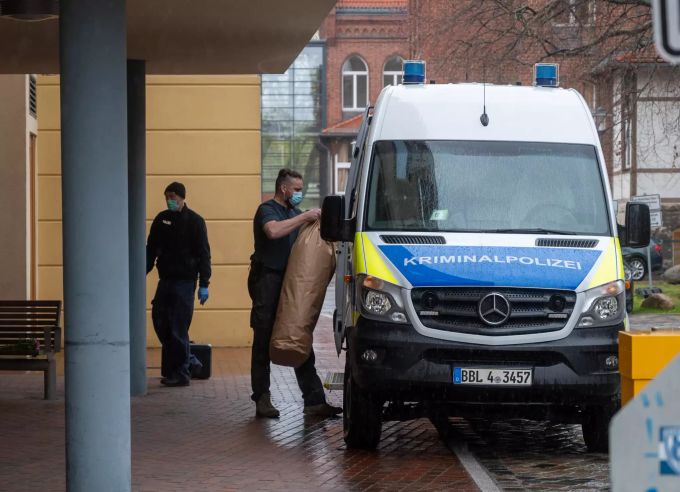 Ein Mitarbeiter der Kriminalpolizei bringt Gegenstände auf dem Gelände einer Potsdamer Klinik in ein Polizeiauto. Vier Tote in Klinik