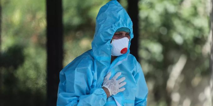 25.04.2021, Indien, Jammu: Ein Verwandter einer Person, die an den Folgen einer Corona-Infektion gestorben ist, reagiert während einer Einäscherung. Coronavirus - Indien
