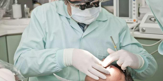 Ein Zahnarzt bei der Behandlung eines Patienten. (Symbolbild) Zahnarzt