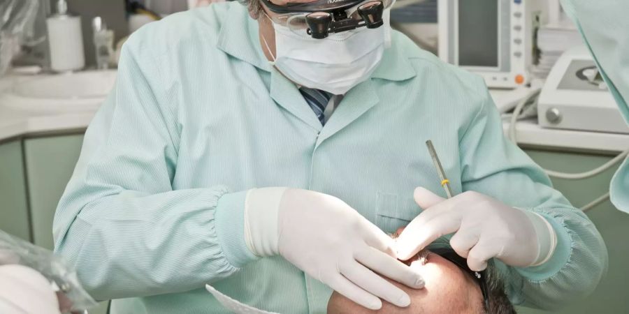 Ein Zahnarzt bei der Behandlung eines Patienten. (Symbolbild)