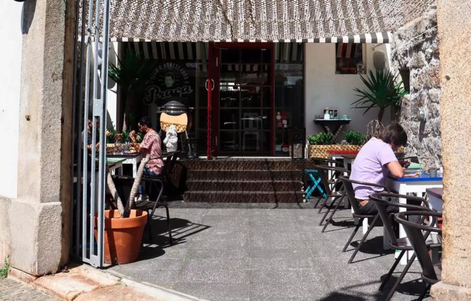 Gäste geniessen die Sonne auf einer Terrasse eines Restaurants in Port porto