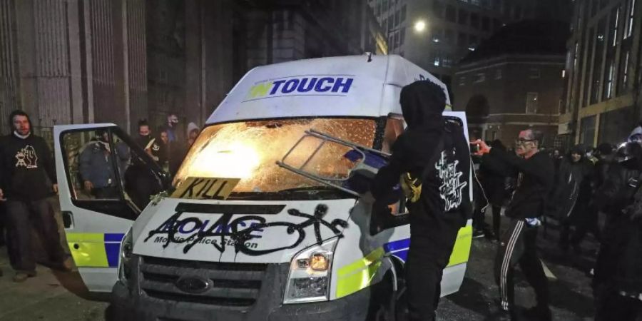 Demonstranten setzen einen Polizeiwagen vor der Bridewell Polizeiwache Brand. Der Protest richtet sich gegen ein neu verabschiedetes Polizeigesetz in Grossbritannien. Foto: Andrew Matthews/PA/dpa