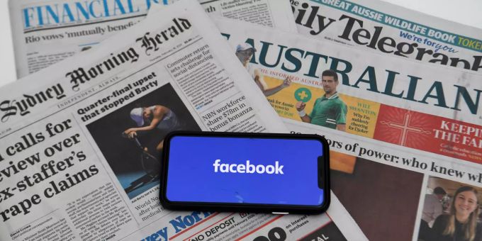 ILLUSTRATION - 18.02.2021, Australien, Canberra: Ein Illustrationsbild zeigt das «Facebook»-Logo auf dem Bildschirm eines Smartphones, das auf australischen Zeitungen liegt. Der Streit zwischen Facebook und der australischen Regierung über ein neues Mediengesetz eskaliert. Als Reaktion auf das Vorhaben hat der Internetgigant jetzt das Teilen von Nachrichteninhalten auf seiner Plattform auf dem Kontinent blockiert. Australische Facebook-Nutzer können demnach keine nationalen oder internationalen journalistischen Inhalte mehr teilen. Foto: Lukas Coch/AAP/dpa +++ dpa-Bildfunk +++ Facebook blockiert Medieninhalte in Australien