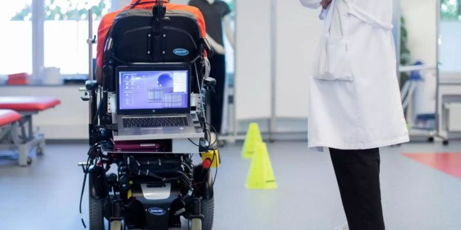 Sarshar Manoucheher, ein querschnittsgelähmter Patient, fährt mit seinen Rollstuhl durch einen Parcours, gesteuert mittels einer Hirn-Computer-Schnittstelle durch Gedankenkraft. Foto: Rolf Vennenbernd