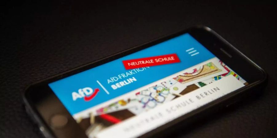 Ein Handy zeigt das Internetportal «Neutrale Schule» der Berliner AfD. Sein Gegenstück in Mecklenburg-Vorpommern ist jetzt verboten worden. Foto: Arne Immanuel Bänsch