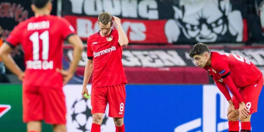 Kai Havertz (r-l) und Lars Bender und Leverkusens Nadiem Amiri (l) sind nach der Niederlage enttäuscht. Foto: Rolf Vennenbernd
