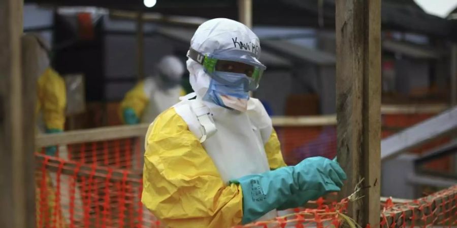 Ein medizinischer Helfer im Schutzanzug arbeitet in einem Ebola-Behandlungszentrum im Kongo. Im Nachbarland Uganda ist die lebensgefährliche Virus-Erkrankung nun auch nachgewiesen worden. Foto: Al-Hadji Kudra Maliro/AP