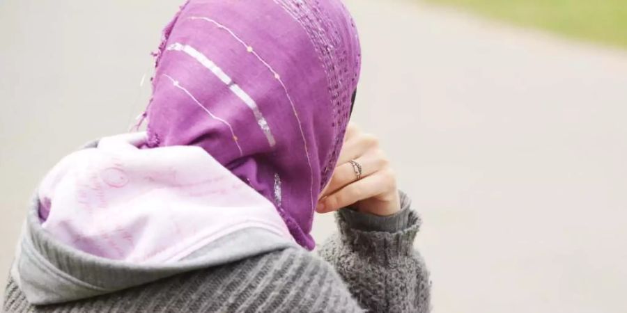 Eine junge Muslimin trägt ein Kopftuch zu einem modernen, westlichen Kapuzenpullover.