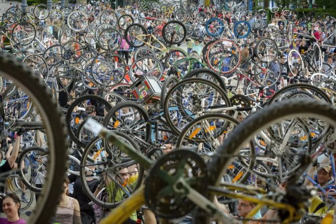 Mehrere Teilnehmer der «Critical Mass» in Ungarn heben ihre Fahrräder in die Lüfte. Critical Mass