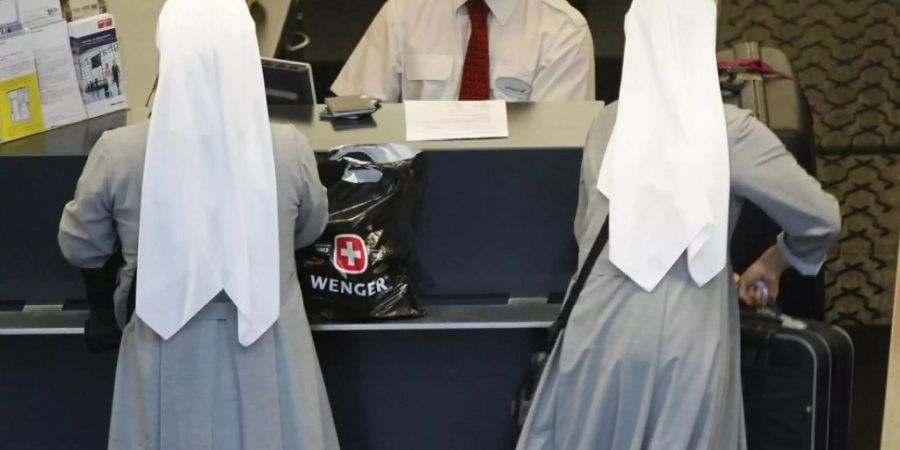 Ordensfrauen am Check-in im Flughafen. Sommerzeit ist Ferienzeit - allerdings nicht für jeden und jede. In der EU können sich im Schnitt 28,3 Prozent der Bürger nicht einmal eine Woche Urlaub leisten. In der Schweiz müssen nur 8,5 Prozent aus Kostengründen daheim bleiben. (Symbolbild)
