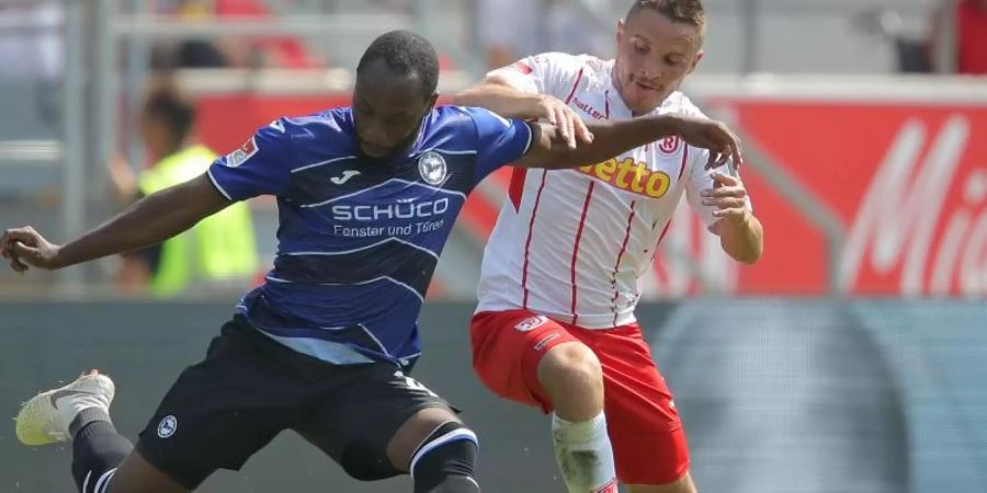 Regensburgs Andreas Geipl (r) kommt gegen Arminia-Torschütze Reinhold Yabo zu spät. Foto: Daniel Karmann