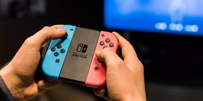 Ein Mann spielt mit der Spielkonsole Nintendo Switch. Nintendo Switch