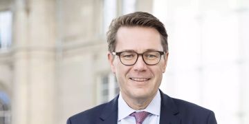 Mann mit kurzen Haaren und Brille im Anzug