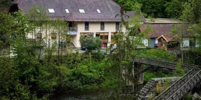 Eine Pension steht von Bäumen umgeben an der Ilz in Paasau. Drei tote Personen sind dort in einem Zimmer gefunden worden. Foto: Lino Mirgeler Eine Pension steht von Bäumen umgeben an der Ilz in Paasau. Drei tote Personen sind dort in einem Zimmer gefunden worden. Foto: Lino Mirgeler