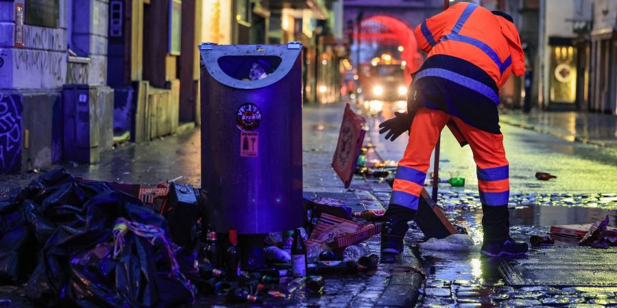 Wo gefeiert wird, fällt Müll an: Mitarbeiter der Strassenreinigung fegen in der Nacht in Köln den Abfall zusammen.