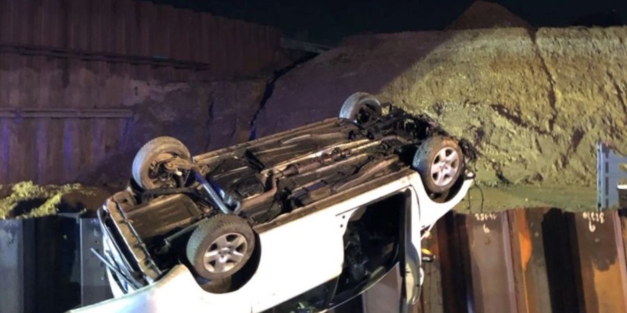 Das Auto liegt auf dem Dach, nachdem es von einer demontierten Autobahnbrücke gestürzt ist. Der Fahrer wurde leicht verletzt.