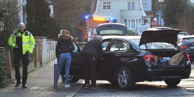 Polizisten untersuchen das Auto des Opfers. Polizisten untersuchen das Auto des Opfers.