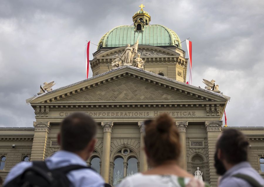 Besucher betrachten das frisch enthüllte Kunstwerk "Tilo" im Giebelfeld, dem Tympanon des Bundeshauses, am öffentlichen Festakt zum 175. Geburtstag der Bundesverfassung und somit der modernen Schweiz, am Dienstag, 12. September 2023 am Bundesplatz in Bern. Das Künstlerpaar Renee Levi und Marcel Schmid hat das Mosaik Tilo aus 246 Keramikplatten geschaffen, passend zu den 246 Parlamentsmitgliedern, die sich jeweils im Innern des Gebäudes tummeln.