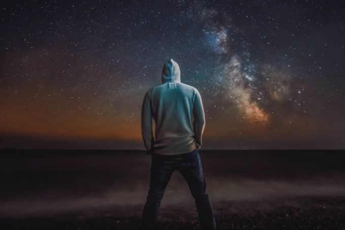 Gedanken, die wir immer wieder denken, manifestieren sich in unserer 3D-Realität. Mann unter Sternenhimmel