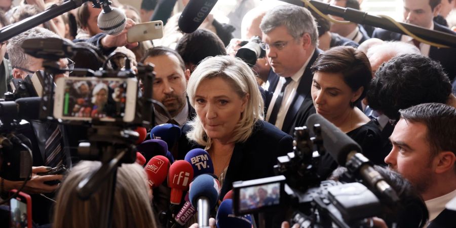 Marine Le Pen, ehemalige Parteivorsitzende der rechtsextremen französischen Partei Rassemblement National, wird in Paris von Reportern umringt.