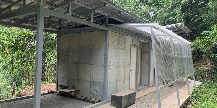 Ein Rohbau eines einfachen Hauses, bei dem gebrauchte Windeln einen Teil des Baumaterials ersetzen.