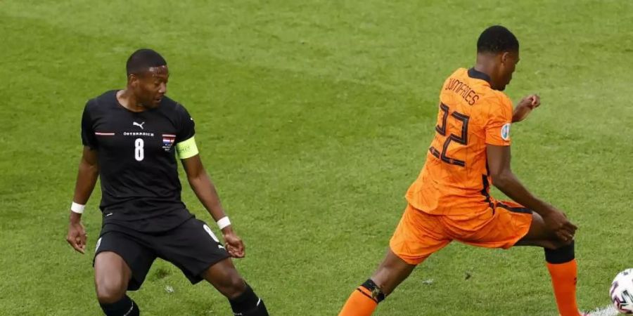 Österreichs David Alaba (l) kommt zu spät und foult den Niederländer Denzel Dumfries und verursacht einen Elfmeter. Foto: Koen Van Weel/EPA Pool/AP/dpa