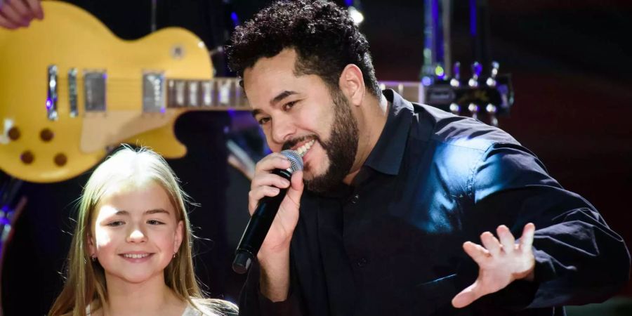 Der deutsche Musiker Adel Tawil steht mit einem Mädchen des Kinderchors «Blue Voice» auf der Bühne.