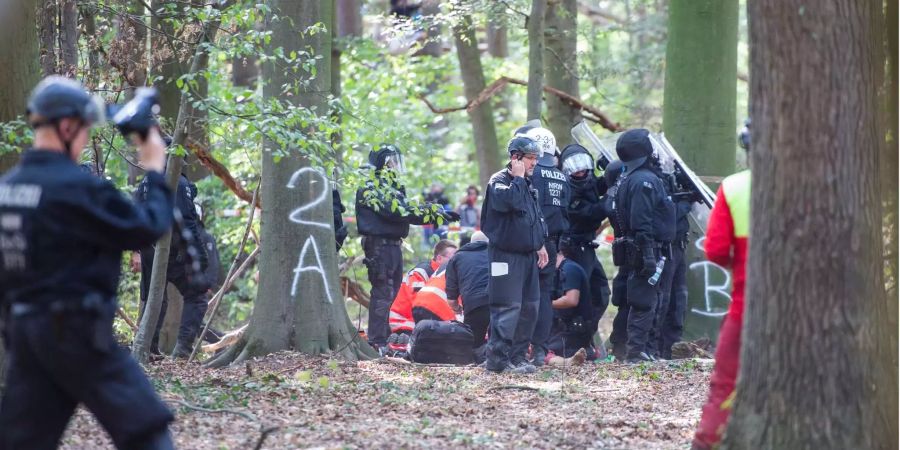 Notärzte versorgen einen Mann, der von einem Baumhaus im Hambacher Forst gefallen ist.