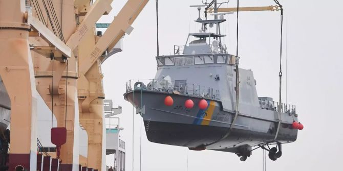 Ein Küstenschutzboot für Saudi-Arabien wird im Hafen auf ein Transportschiff verladen.