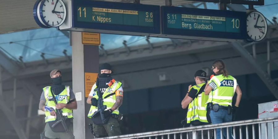 Kölner Polizisten stehen nach der Geiselnahme auf einem Bahnsteig des Hauptbahnhofs.