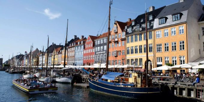 Ein Touristenschiff fährt durch den alten Kopenhagener Hafen «Nyhavn». kopenhagen
