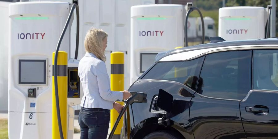 Eine Autofahrerin lädt ihr Elektroauto an einer Ultraschnellladestation.