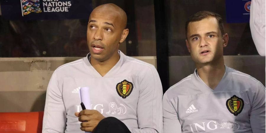 Thierry Henry (links), Assistenztrainer von Belgien, sitzt vor dem Spiel gegen die Schweiz auf der Bank.