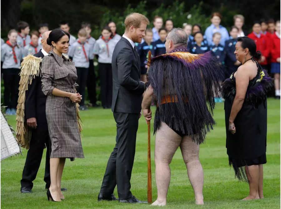 Harry und Meghan unterhalten sich während der traditionellen Begrüssungszeremonie in Neuseeland im Garten des Gouverneurshauses mit Schulkindern.