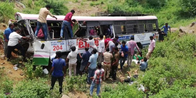 Personen helfen, die Opfer eines Busunfalls in Indien zu befreien.