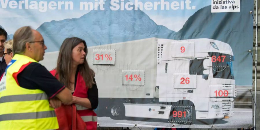 Aktivisten der Alpeninitiative stehen vor einem Plakat.