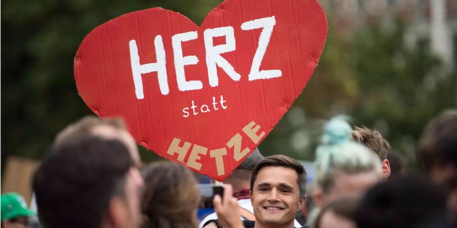 Ein Teilnehmer der Kundgebung des Bündnisses Chemnitz Nazifrei unter dem Motto «Herz statt Hetze» hält ein Schild in Form eines Herzen hoch.