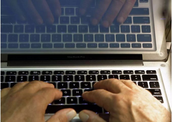Die Hände eines Mannes sind auf der Tastatur eines Mac Book Pro - Keystone Die Hände eines Mannes sind auf der Tastatur eines Mac Book Pro - Keystone