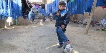 Murtasa Ahmadi steht in einem Hof mit einm Fussball.