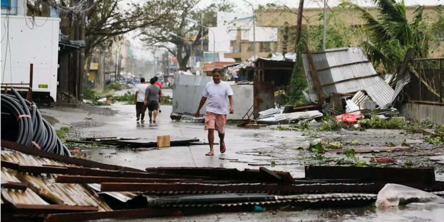 Anwohner gehen über eine verwüstete Strasse, nachdem der Taifun «Mangkhut» wütete.