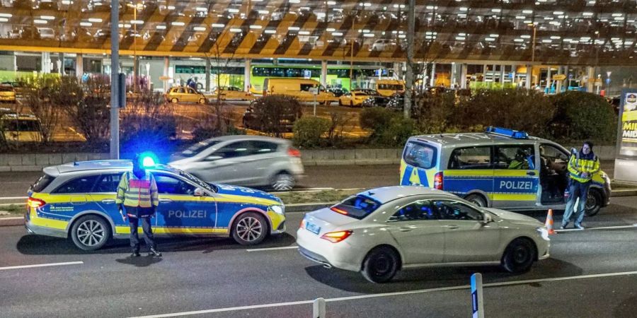 Polizisten kontrollieren eine Zufahrt zum Flughafen.