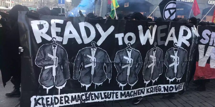 «Ready to W(e)ar – Kleider machen Leute machen Krieg. No WEF» steht auf einem Banner der Demonstranten.