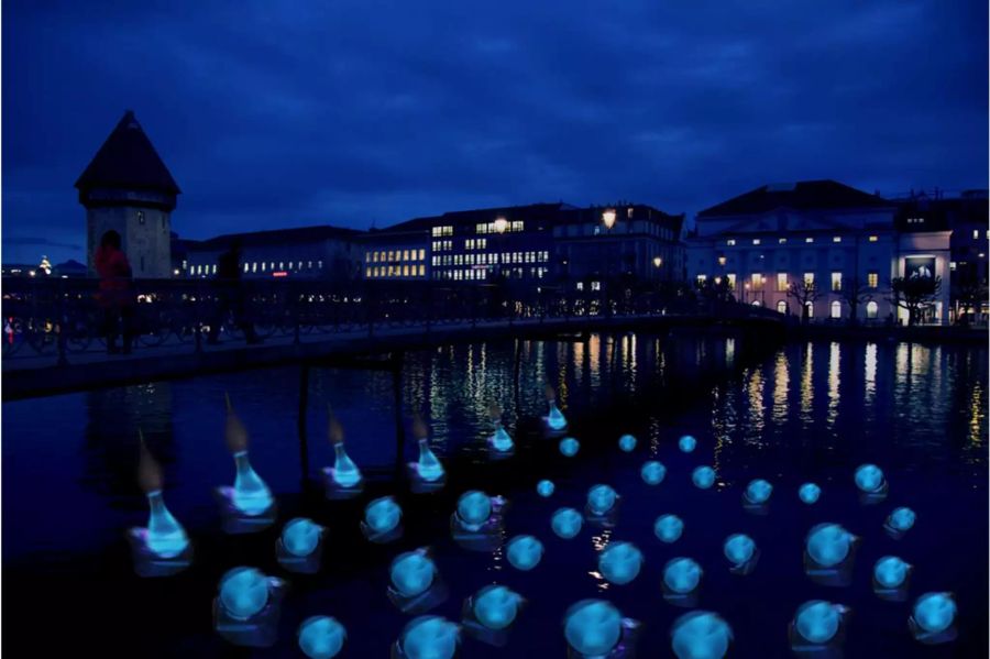 Mitten in der Reuss leuchten Kugeln aus dem Wasser.