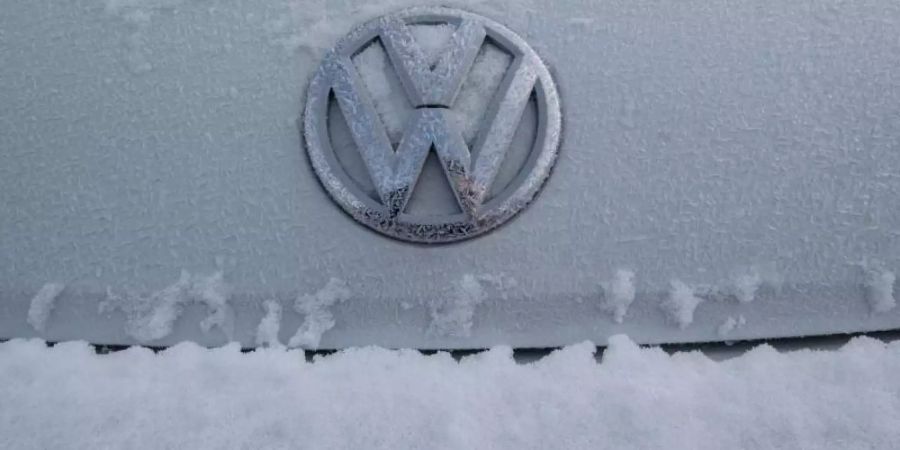Das mit Eiskristallen überzogene Logo eines VW auf dem Hof eines Händlers in Detroit. Foto: Boris Roessler